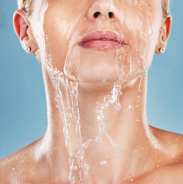 Vrouw gezicht, water spatten en schoonmaken huid, wellness en douche in blauwe studio mockup achtergrond. Mock up, model cosmetische en schoonmaak lichaam met gezichtsbehandeling, schoon en bad voor hygiëne en hydratatie. - Foto, afbeelding