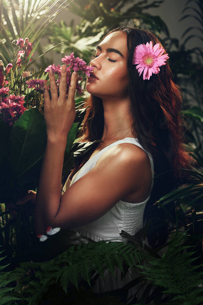Young woman, nature and smell flowers, plants and content with environment, happy and peaceful outdoor. Female, girl and happiness, natural aroma, fragrance or tranquil for scent, serene and floral - Foto, immagini
