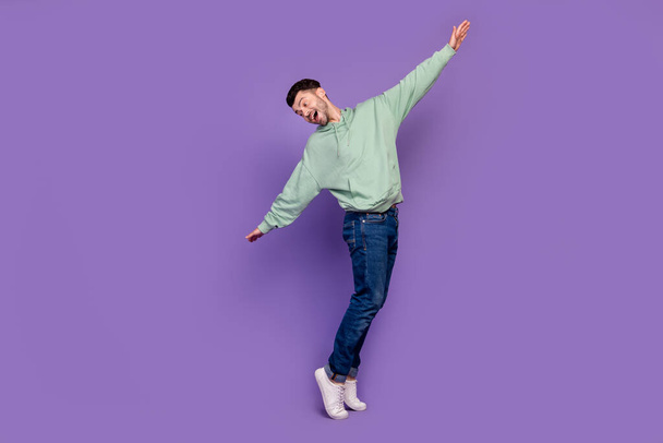Lunghezza completa foto di giovane bell'uomo scapolo che balla punta di piedi spensierato godersi la sua vita week-end relax isolato su sfondo di colore viola pastello. - Foto, immagini