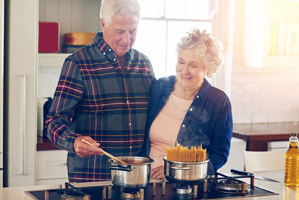 Готують разом у самому серці свого дому. старша пара готує разом на своїй кухні вдома
 - Фото, зображення