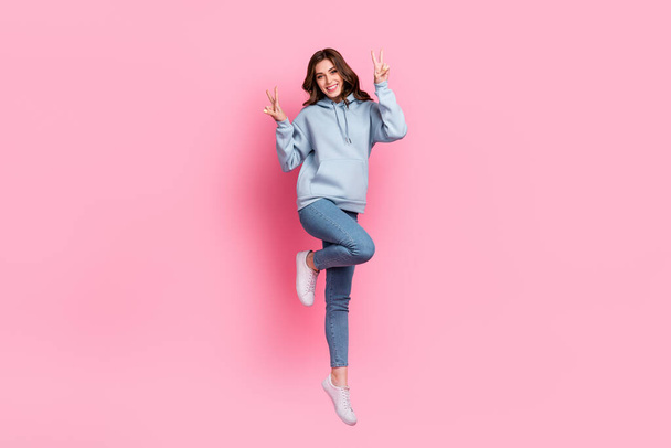 Full body photo of cheerful pretty lady jumping demonstrate v-sign isolated on pink color background. - Photo, image