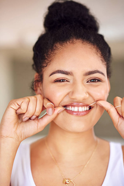 Dándole una limpieza profunda a su sonrisa. Retrato de una joven que usa hilo dental - Foto, Imagen