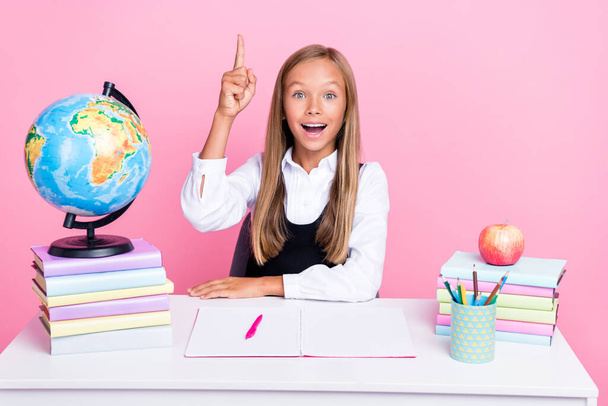 Photo of young pretty cute preteen schoolkid girl wear formal uniform time back to school sitting desk idea solution isolated on pink color background. - Фото, зображення