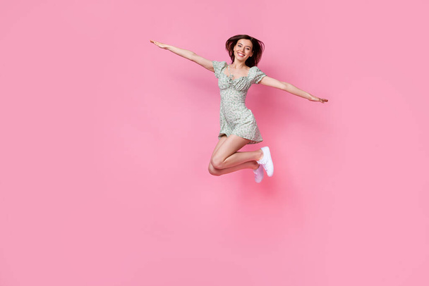 Full length photo of adorable shiny lady wear green clothes jumping high arms sides empty space isolated pink color background. - Fotoğraf, Görsel