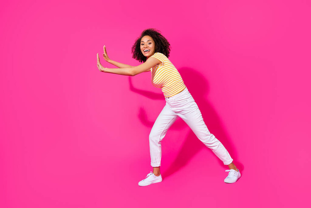 Full length photo of young adorable cute woman wear summer stylish outfit push abstract object empty space isolated on pink color background. - 写真・画像