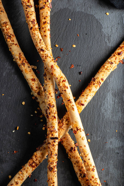 Grissini com Chilli Flakes, também conhecido como breadsticks, grissino, ou palitos de imersão, são geralmente palitos do tamanho de lápis de pão crocante e seco originários da Itália.. - Foto, Imagem