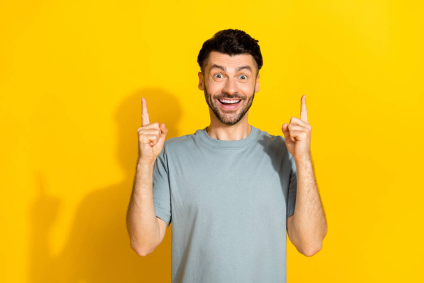 Photo of funky excited positive brunet man student genius idea solution cash problem eureka success fingers pointing up isolated on yellow color background. - Foto, imagen