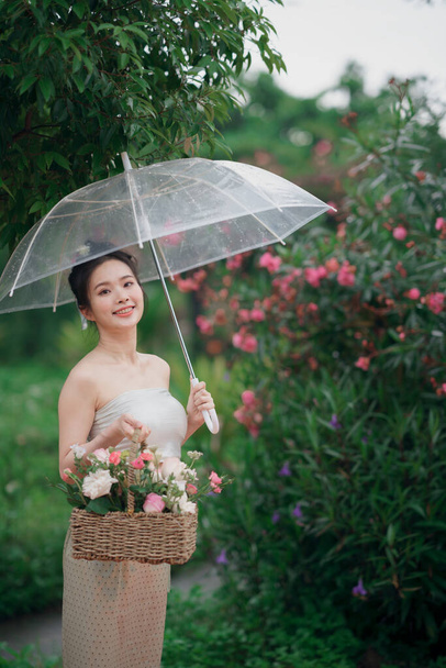 Το κορίτσι με το παραδοσιακό κινέζικο φόρεμα είναι στον κήπο. - Φωτογραφία, εικόνα