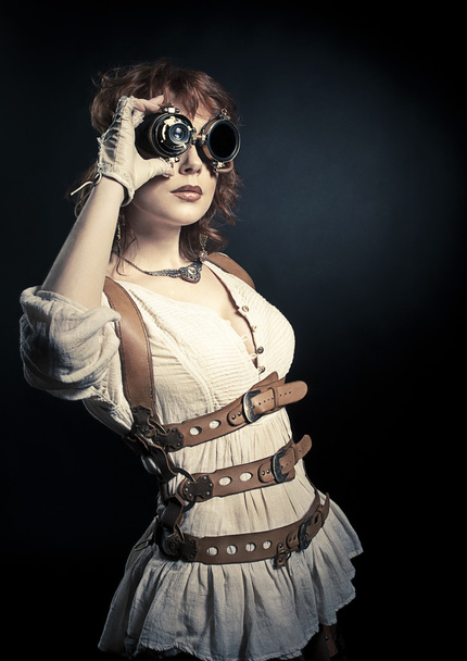 Steampunk woman looking over her goggles - Фото, изображение