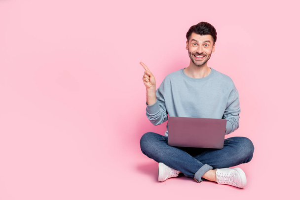 Full body photo of nice young man laptop manager hr finger point empty space wear stylish blue garment isolated on pink color background. - Photo, image