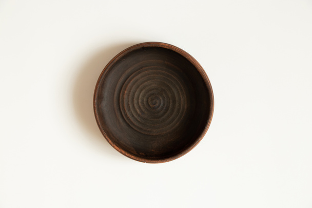 Earthenware deepware stands on a white background close-up - Фото, зображення
