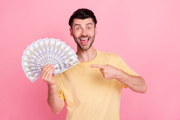 Photo of overjoyed successful man win lottery arm demonstrate million luxury life good mood isolated on pink color background. - Foto, Bild