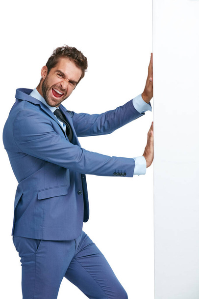 Challenge your limits. Studio shot of a handsome businessman pushing a wall against a white background - Foto, Imagem