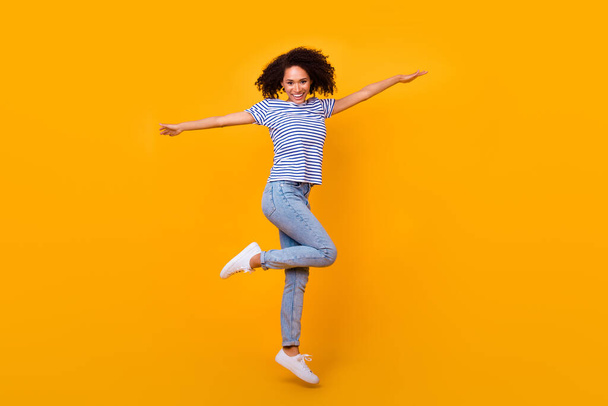 Full body photo of energetic cheerful girl jump have good mood rejoice isolated on yellow color background. - Fotó, kép