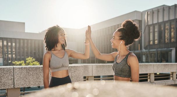 Fitness, friends and high five in the city for exercise, training or workout together in the outdoors. Happy women in partnership touching hands for sports support, success or healthy cardio wellness. - Photo, image