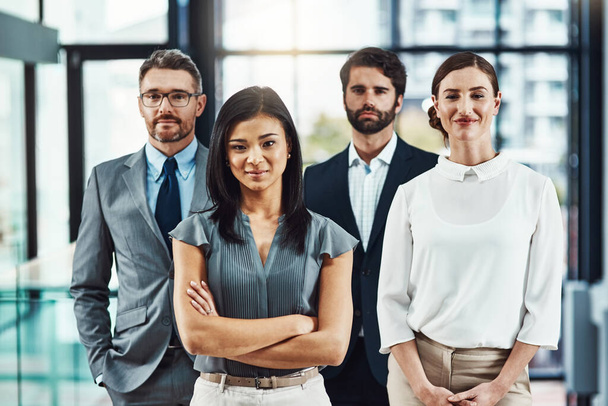 Vamos mais longe para o profissionalismo. Retrato de uma equipe corporativa confiante em pé juntos em um escritório moderno - Foto, Imagem