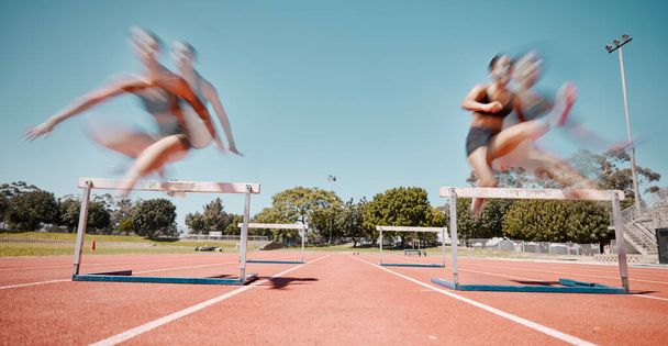 Fitness, jump or running women in a hurdles sports competition or athletes racing event with speed. Training, exercise and fast girl sprinters jumping in a track and field race at a runners stadium. - Photo, Image