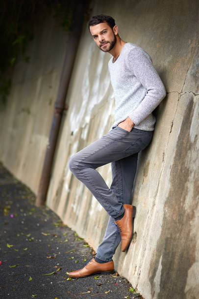 El estilo no se acaba de encontrar en la pista. un joven guapo posando contra una pared urbana - Foto, Imagen