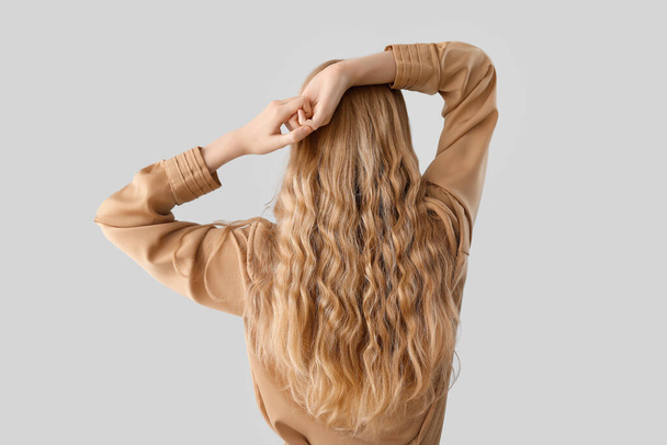 Woman with beautiful curly hair on light background - Zdjęcie, obraz