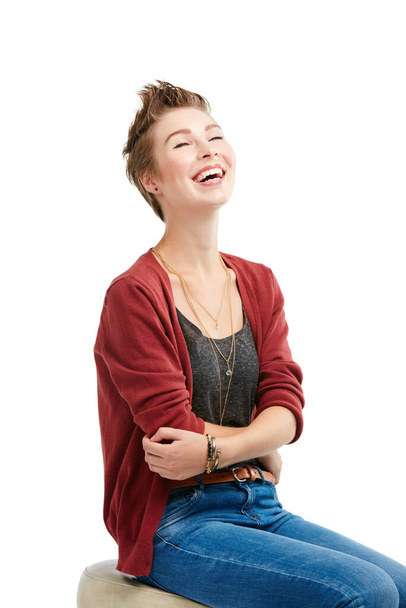 Laughter is a universal language. Studio portrait of a joyful young woman sitting on a chair against a white background - Photo, Image