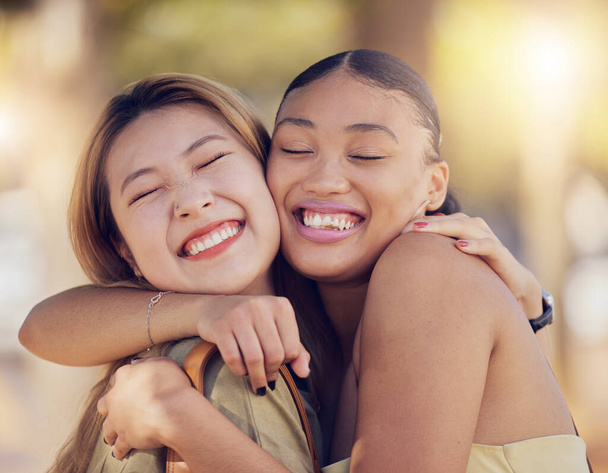 Friends, women and hug for love, care and support while outdoor for travel, happiness and bonding with asian and black woman. Lesbian couple with a smile in nature for peace, summer and time together. - Foto, immagini