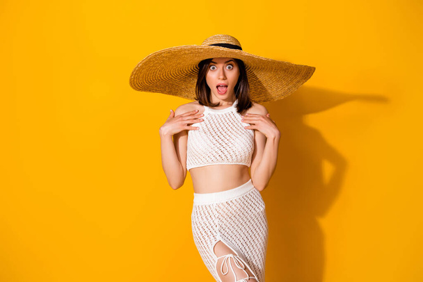 Photo of cute impressed girl dressed knitted bra straw cap big eyes open mouth isolated yellow color background. - 写真・画像