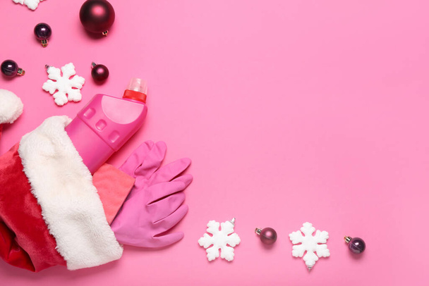 Mikulás kalap tisztítószerek és karácsonyi dekoráció rózsaszín háttér - Fotó, kép
