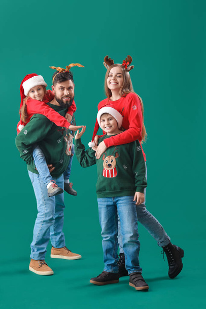 Joyeux famille en vêtements de Noël sur fond vert - Photo, image
