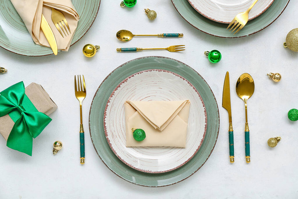 Όμορφη ρύθμιση τραπέζι με μπάλες Χριστούγεννα και δώρο σε λευκό φόντο - Φωτογραφία, εικόνα