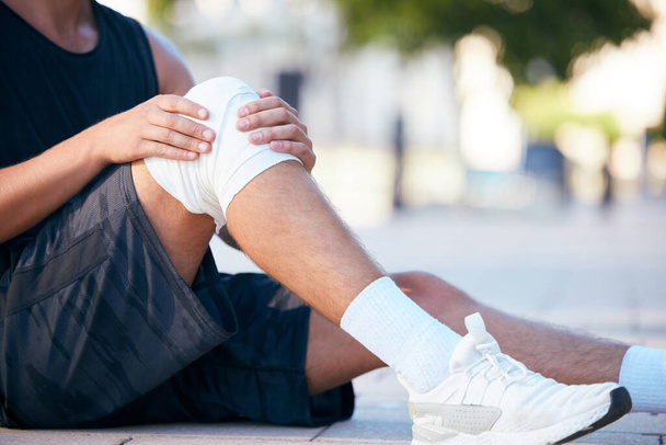 Knee injury pain, runner or man hurt from fitness, exercise or sports cardio workout for athlete healthcare. Accident emergency, ground floor or legs of training person with medical first aid bandage. - Photo, Image