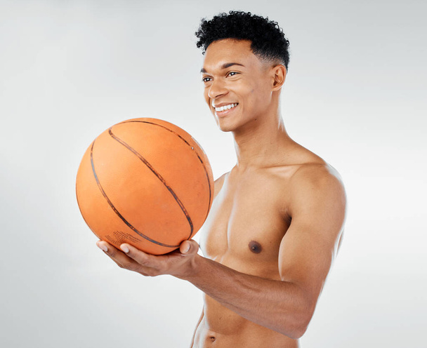 Μπάσκετ, fitness και μαύρος άνδρας σε studio training, άσκηση και ευεξία με χαμόγελο για αθλητικό διαγωνισμό. Δύναμη, μυς και χαρούμενος αθλητής, παίκτης μπάσκετ ή μοντέλο με μια μπάλα για προπόνηση παιχνίδι. - Φωτογραφία, εικόνα