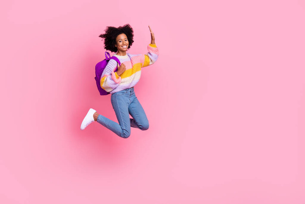 Full length photo of sweet excited little child dressed pastel pullover jumping high waving arm empty space isolated pink color background. - Fotó, kép