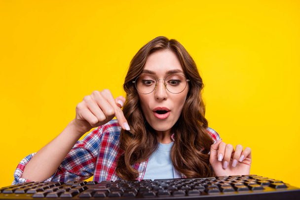 Portrait of cute girlish positive woman curly hairstyle checkered shirt finger typing keyboard isolated on yellow color background. - Foto, Bild