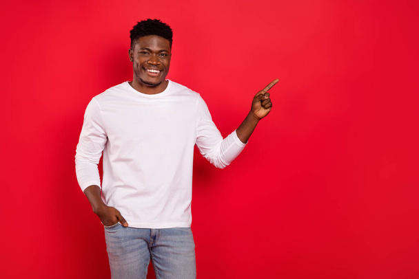 Photo of cheerful person indicate finger empty space promotion isolated on red color background. - Fotó, kép