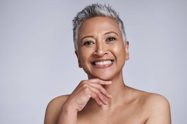Skincare, beauty and portrait of a senior woman with a natural, organic and cosmetic face routine. Happy, smile and elderly lady with a facial skin treatment isolated by a gray background in a studio. - Foto, immagini