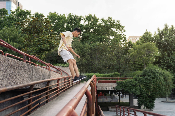 Confident young man practicing parkour in the park and having fun. - Photo, image