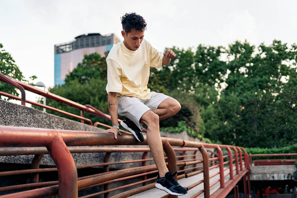 Confident young man practicing parkour in the park and having fun. - 写真・画像