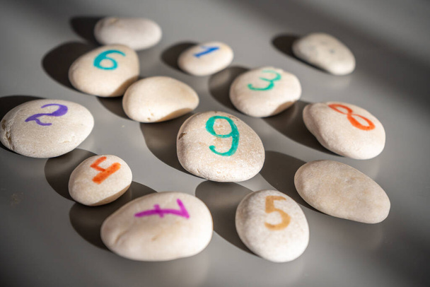 Pedras coloridas assinadas por números, um método alternativo de educação infantil. Número 9 no centro. Foto de alta qualidade - Foto, Imagem