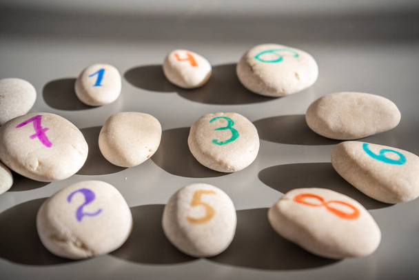 Pedras coloridas assinadas por números, um método alternativo de educação infantil. Número 3 no centro. Foto de alta qualidade - Foto, Imagem