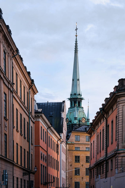 Stockholm, Schweden - September 2022: Bunte Gebäude der Altstadt Gamla Stan oder Staden Mellan Broarna, mit Glockenturm der Deutschen Kirche (Sankta Gertruds kyrka)) - Foto, Bild