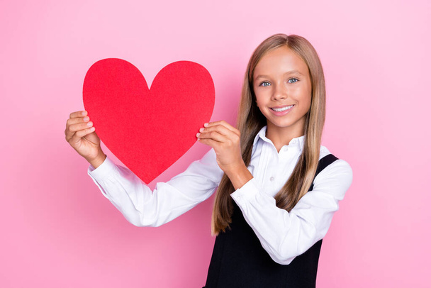 Photo of cheerful pretty stylish girl hand hold show demonstrate big red paper heart figure empty space isolated on pink color background. - Zdjęcie, obraz