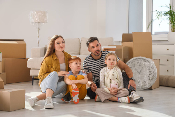Family sitting on floor in new apartment. Moving day - Fotoğraf, Görsel