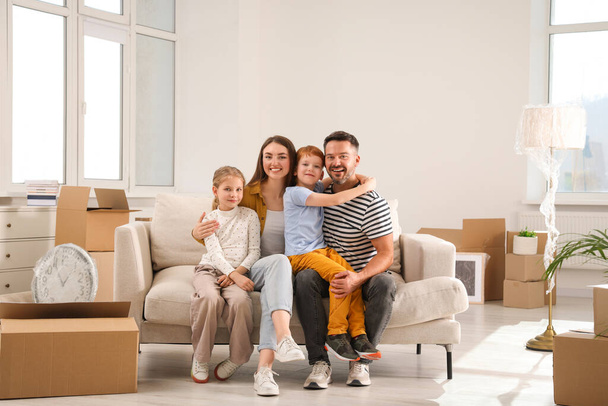 Happy family sitting on couch in new apartment. Moving day - Фото, зображення