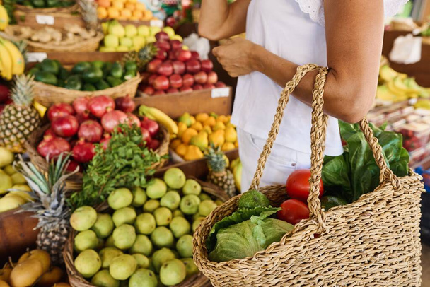 Eine junge Frau kauft Obst und Gemüse auf einem Markt. frische und gesunde Lebensmittel. Hochwertiges Foto - Foto, Bild