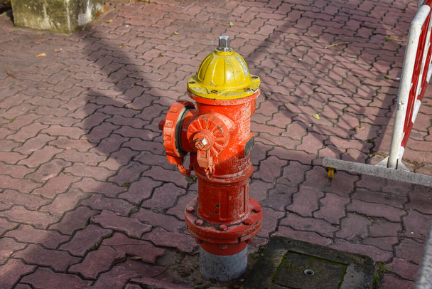 Old red public fire hydrant faucet on public pavement in VietNam - Photo, Image