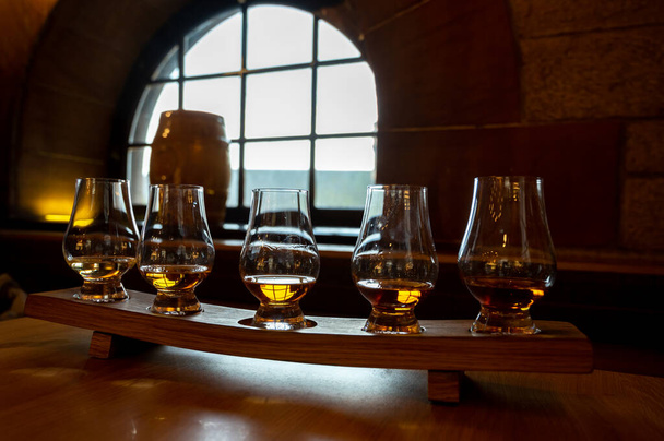 Flight of single malt scotch whisky in glasses served in bar in Edinburgh, UK, tasting of dram of whiskey - Photo, Image