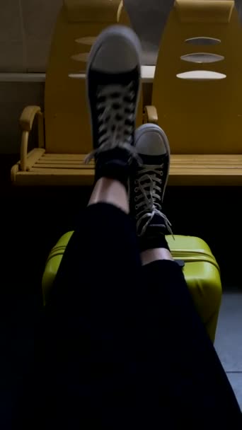 γυναίκα έβαλε τα πόδια της στη βαλίτσα περιμένοντας το λεωφορείο του τρένου - Πλάνα, βίντεο