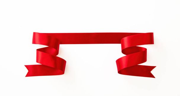 Αγίου Βαλεντίνου riibbon πανό. Κόκκινη σατέν ταινία που απομονώνεται σε λευκό φόντο, πάνω όψη, αντιγραφή χώρου. Χριστουγεννιάτικη διακόσμηση - Φωτογραφία, εικόνα