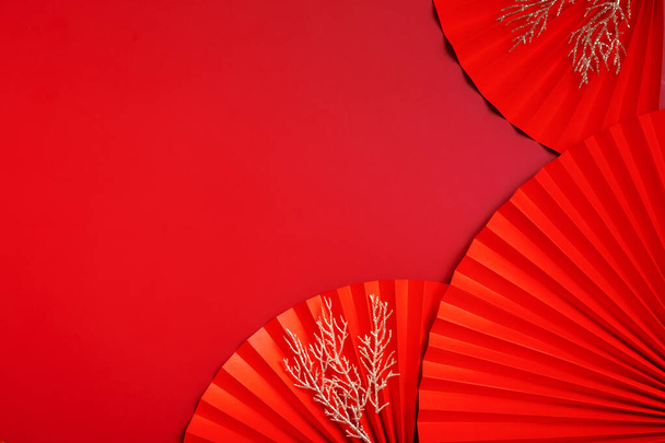 Paper fans symbol Chinese new year top view with copy space. Monochrome red background. - Фото, зображення