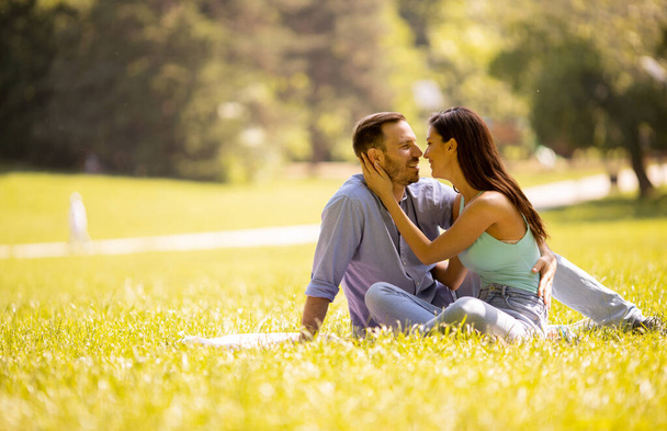 Heureux jeune couple amoureux au champ d'herbe un jour d'été - Photo, image